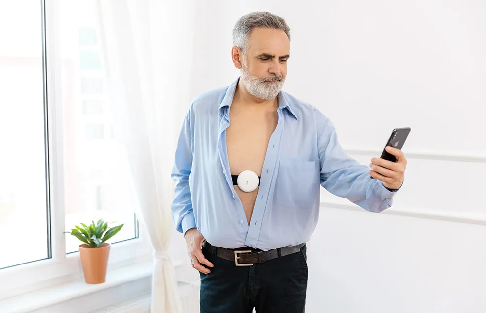 A man checks the Aidmed Health app while wearing Aidmed One